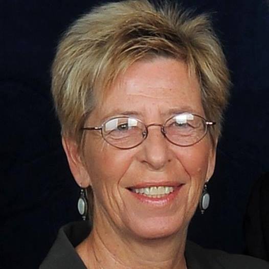 Linda Elliott Portrait - woman wearing glasses and earrings, with short blond hair
